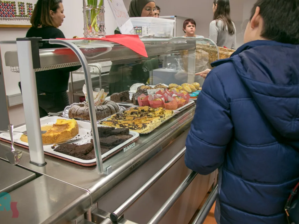 Besucher an der Kuchentheke in der Cafeteria.